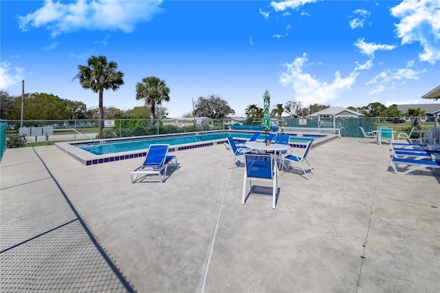 pool with a patio area and fence