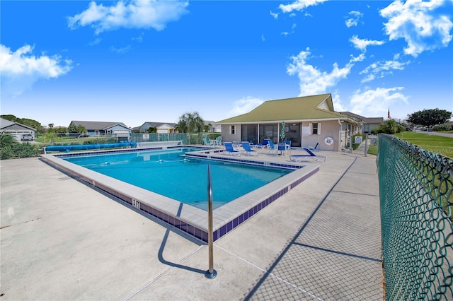 community pool featuring fence and a patio