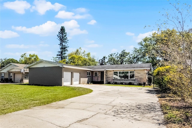 ranch-style house with stone siding, driveway, a front lawn, and a garage