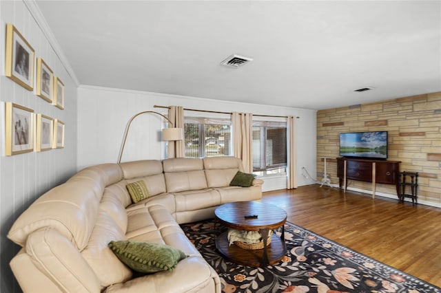 living area featuring visible vents, crown molding, and wood finished floors