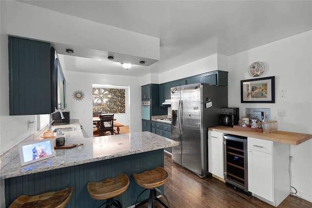 kitchen featuring stainless steel fridge, a peninsula, beverage cooler, and dark wood finished floors