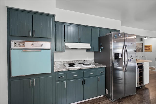 kitchen with under cabinet range hood, white electric cooktop, wall oven, stainless steel fridge, and wine cooler