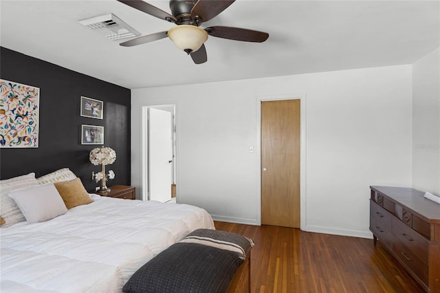 bedroom with ceiling fan, visible vents, baseboards, and wood finished floors