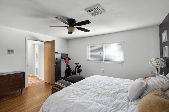 bedroom with visible vents, baseboards, ceiling fan, and wood finished floors