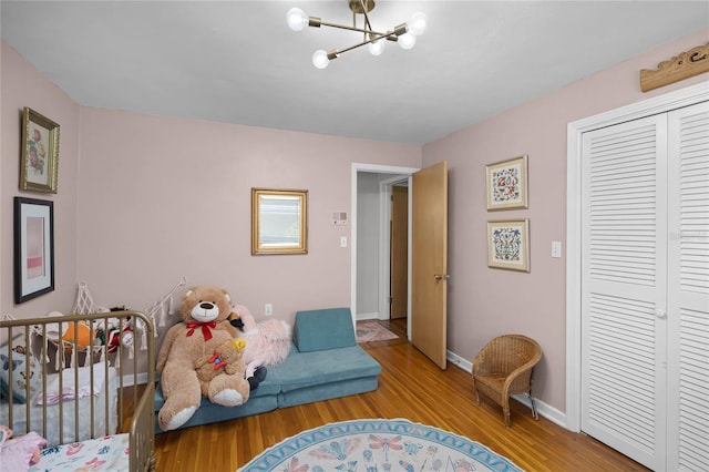 living area featuring a notable chandelier, wood finished floors, and baseboards