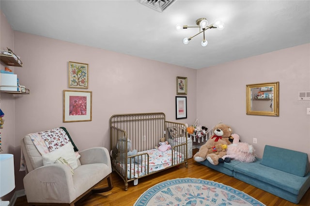 bedroom featuring visible vents and wood finished floors