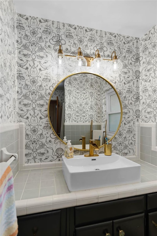 bathroom with wallpapered walls and vanity