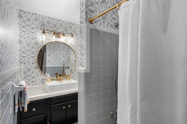 bathroom with vanity and wallpapered walls