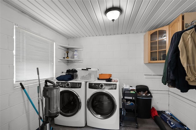 washroom with laundry area, washer and dryer, and concrete block wall