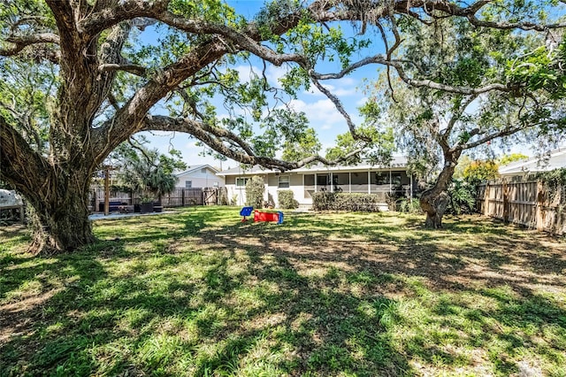 view of yard with a fenced backyard and a sunroom