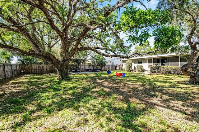 view of yard featuring a fenced backyard and a sunroom