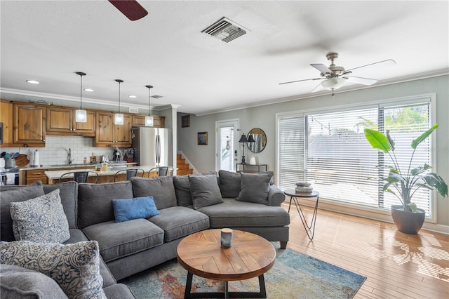 living room featuring a ceiling fan, a wealth of natural light, and visible vents