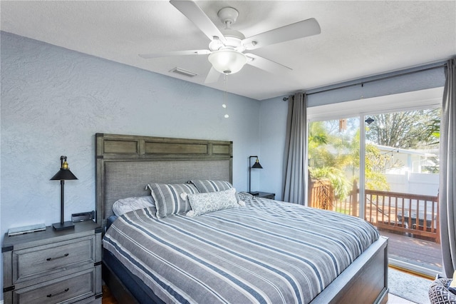 bedroom with access to exterior, ceiling fan, visible vents, and a textured wall