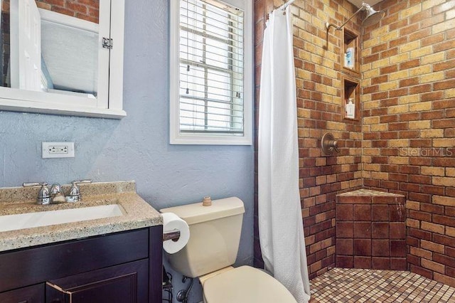 full bathroom featuring toilet, vanity, a tile shower, and a textured wall