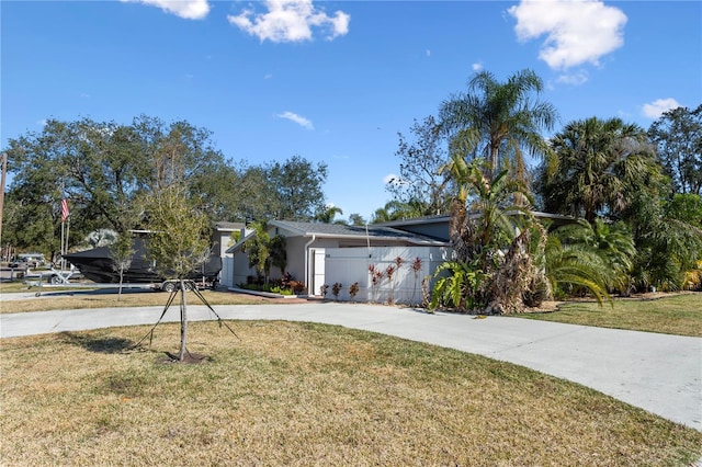 view of front of home with a front yard, driveway, and stucco siding