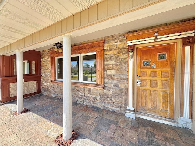 view of exterior entry with stone siding and board and batten siding