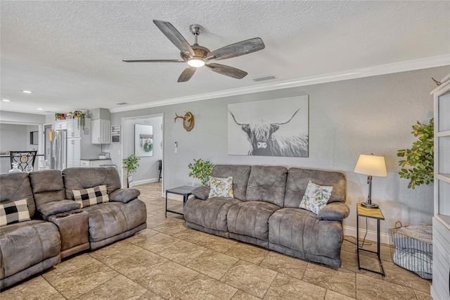 living area with a textured ceiling, crown molding, and baseboards