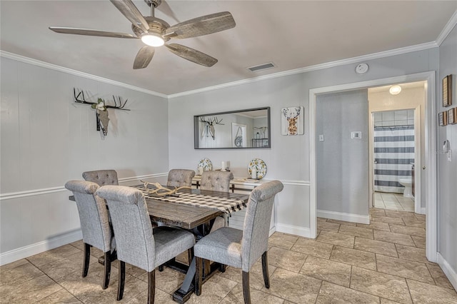 dining room featuring visible vents, baseboards, a ceiling fan, and ornamental molding