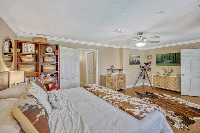 bedroom featuring crown molding, baseboards, visible vents, and a textured ceiling