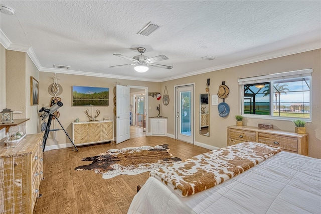 bedroom with visible vents, multiple windows, and light wood-style floors