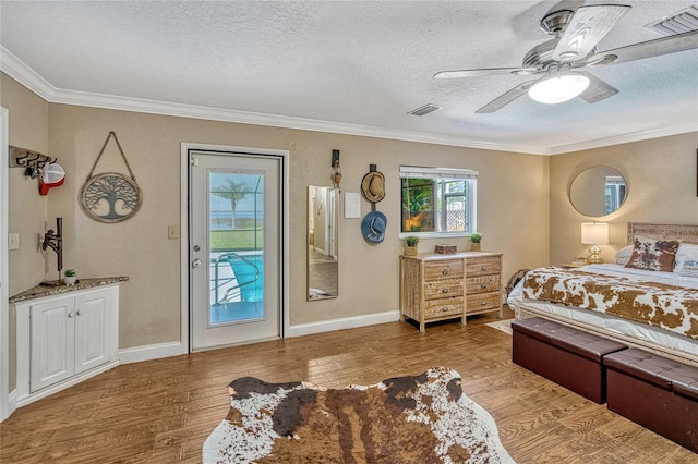 bedroom featuring wood finished floors, visible vents, access to exterior, a textured ceiling, and crown molding