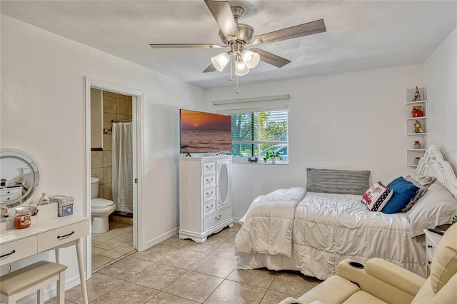 bedroom featuring light tile patterned floors, a ceiling fan, baseboards, and ensuite bathroom