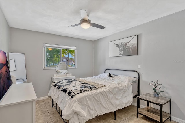 bedroom featuring light tile patterned flooring, a ceiling fan, and baseboards