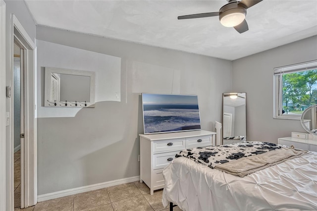 bedroom featuring light tile patterned floors, baseboards, and ceiling fan