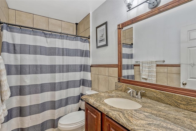 full bath with a shower with curtain, toilet, tile walls, and vanity