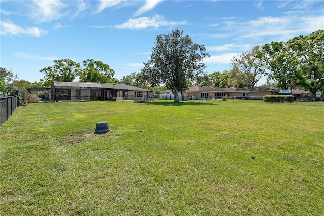 view of yard featuring a lanai and fence