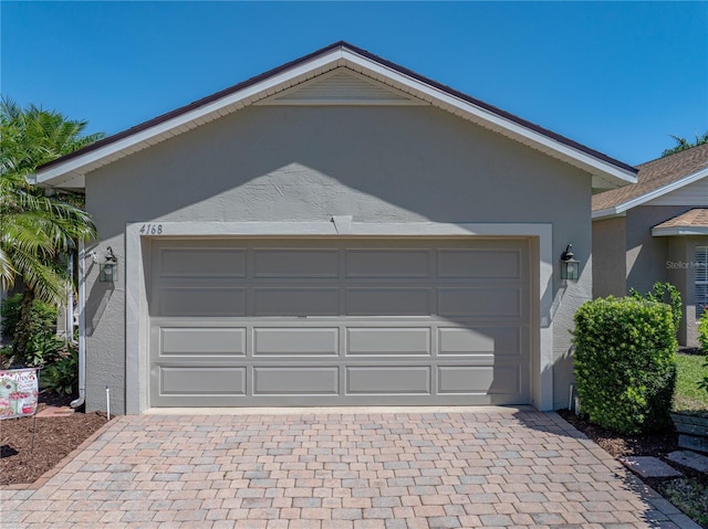 garage with decorative driveway