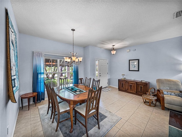 dining room featuring light tile patterned floors, a textured ceiling, a chandelier, and visible vents