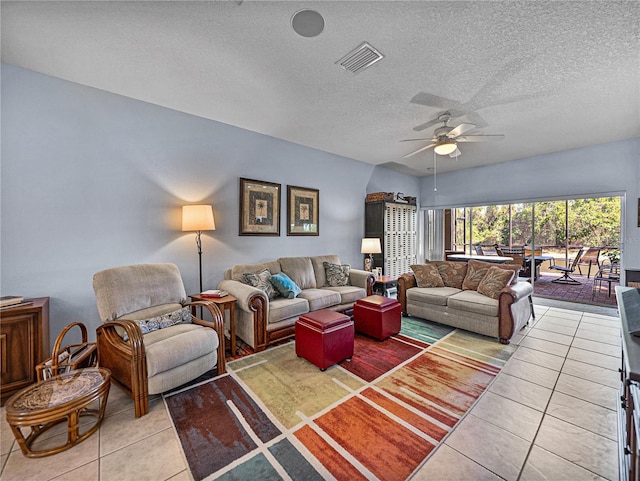 living room featuring a textured ceiling, a ceiling fan, visible vents, and light tile patterned floors