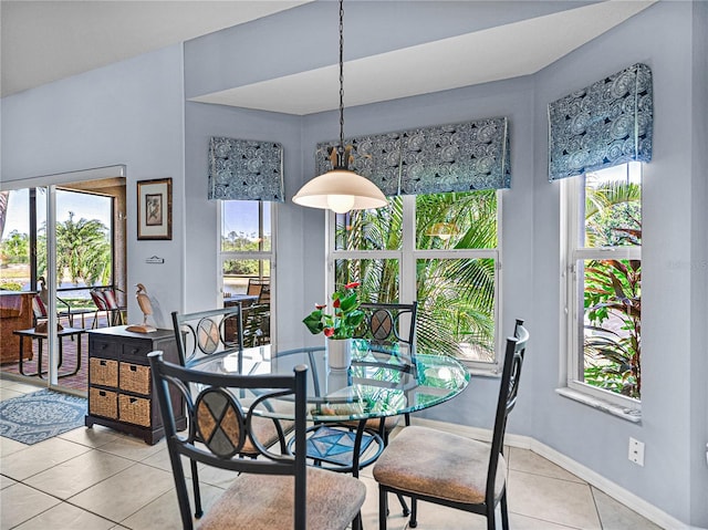 dining area with light tile patterned flooring, baseboards, and a healthy amount of sunlight