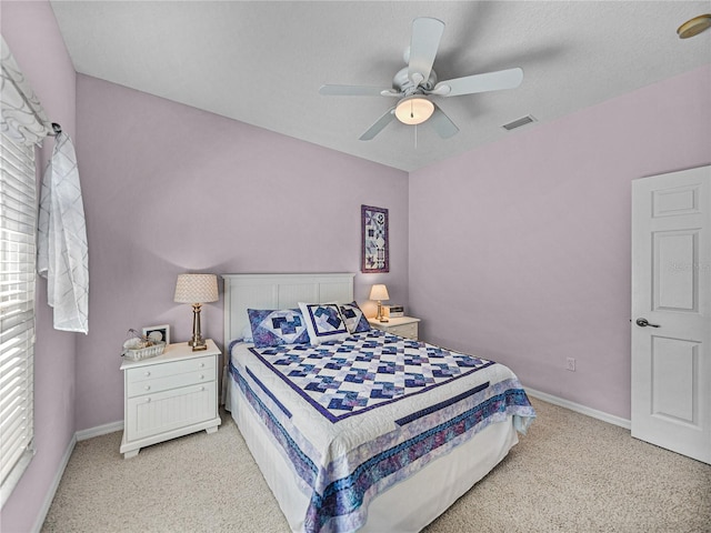 bedroom with light colored carpet, visible vents, and baseboards