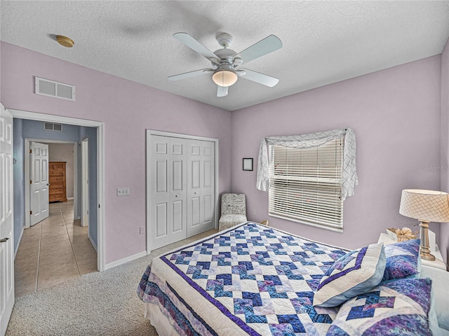 bedroom featuring light carpet, visible vents, and a textured ceiling