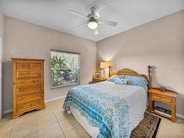 bedroom with baseboards, a textured ceiling, ceiling fan, and light tile patterned floors