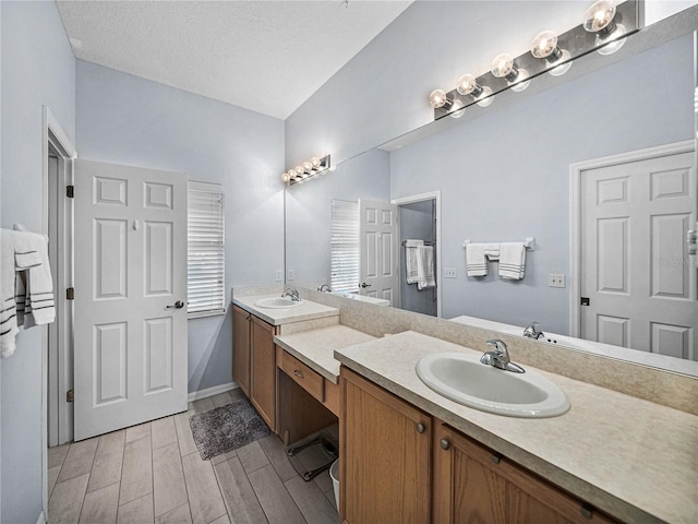 full bathroom featuring a textured ceiling, vanity, and wood finish floors