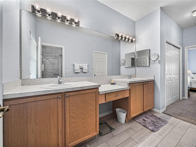 ensuite bathroom featuring ensuite bathroom, baseboards, vanity, and a textured ceiling