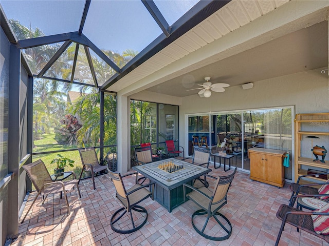 sunroom featuring an outdoor fire pit, a ceiling fan, and beam ceiling