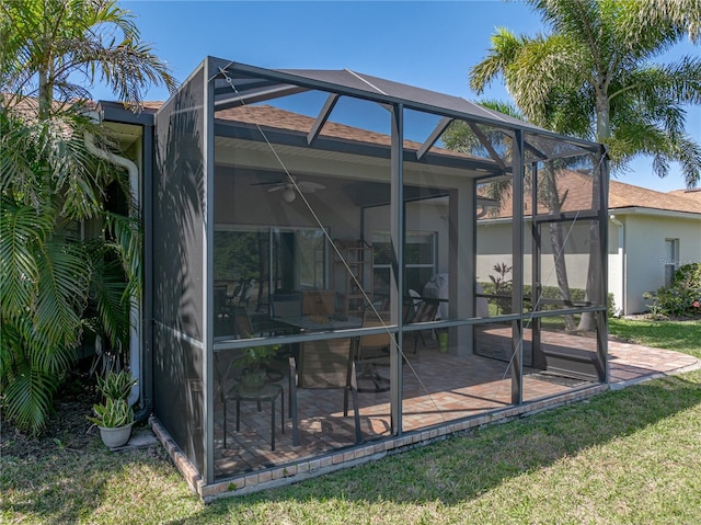 rear view of house with ceiling fan, a lanai, and a patio area