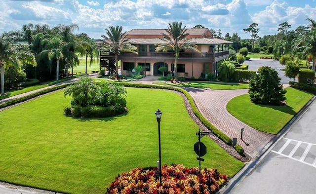 view of community featuring curved driveway and a yard