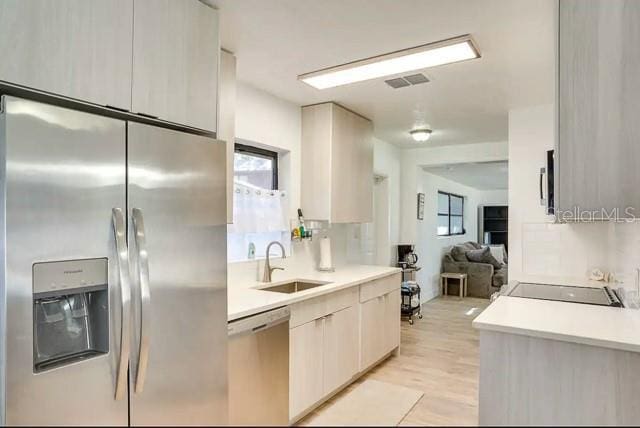 kitchen with light countertops, visible vents, appliances with stainless steel finishes, and a sink