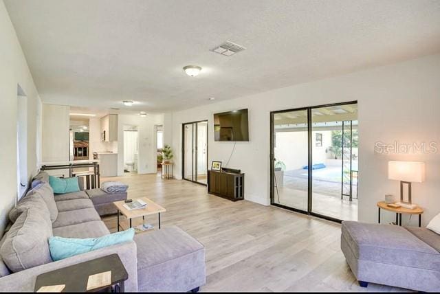 living room featuring visible vents and light wood-type flooring