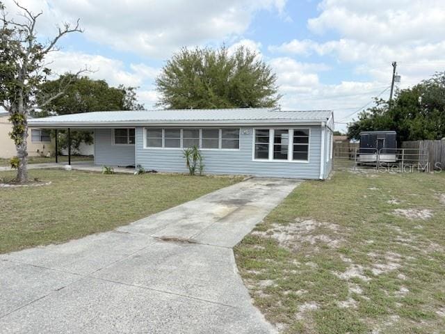 view of front of home featuring metal roof, a front yard, and fence