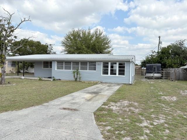 view of front of house featuring metal roof, a front yard, and fence