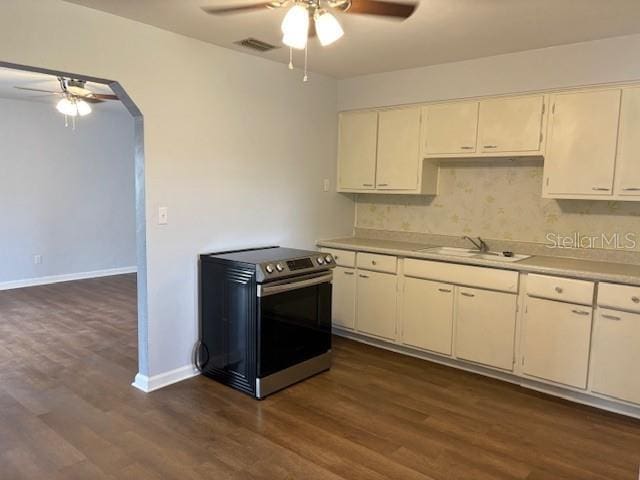 kitchen with visible vents, stainless steel electric stove, light countertops, arched walkways, and a sink