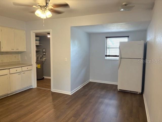 unfurnished dining area featuring baseboards, dark wood-style flooring, and ceiling fan