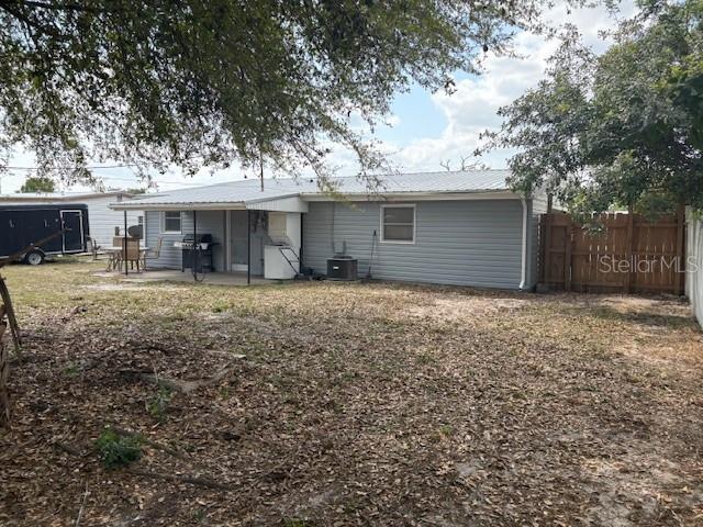 back of house featuring a patio area, central AC unit, metal roof, and fence