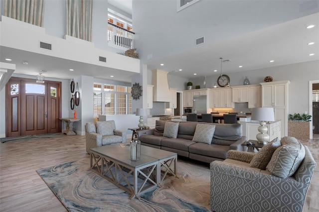 living area featuring recessed lighting, visible vents, and light wood-type flooring